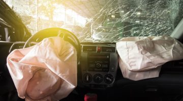 Blown airbags and wrecked windshield of a car that has been in an accident.