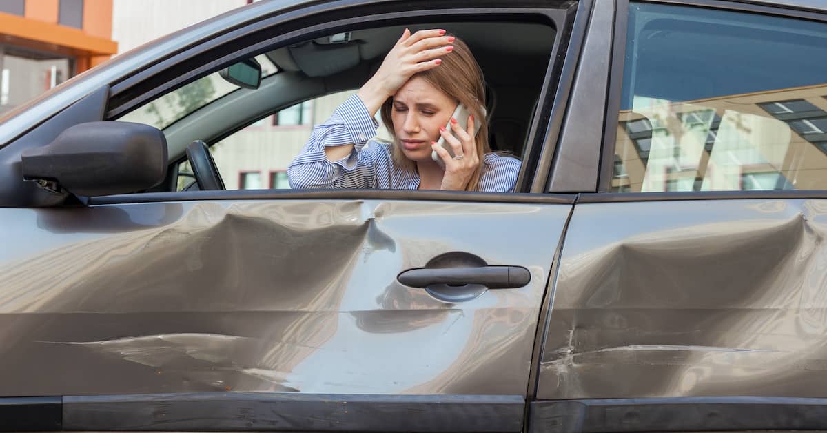 woman holding her head after suffering brain injury in a car accident