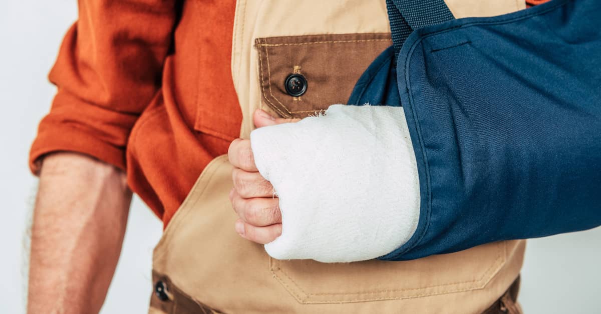 workman with a broken arm in a cast and sling