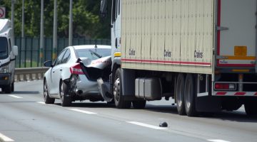 Car rear-ended by truck.