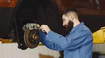 Auto mechanic working on a car's defective brake.