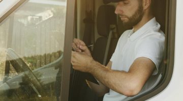 Truck driver checking hours of service (HOS) on electronic device.